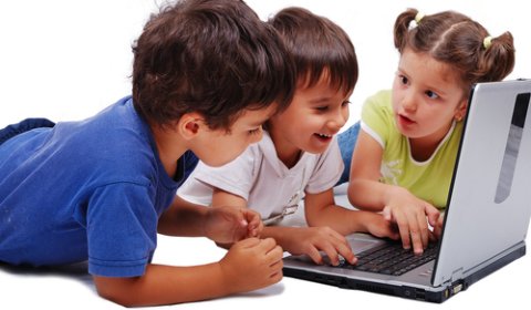 three young children using a desktop computer together